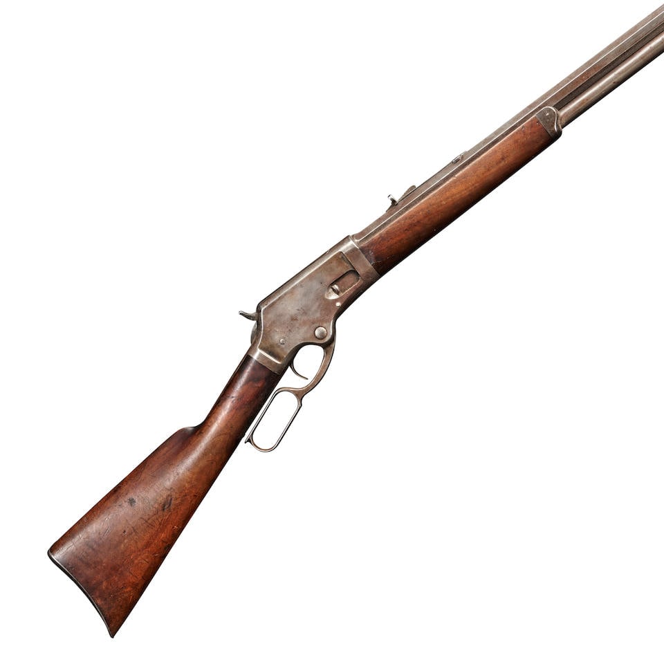 A MARLIN MODEL 1881 LEVER ACTION RIFLE IN .45-70 GOVT. CALIBER.: A MARLIN MODEL 1881 LEVER ACTION RIFLE IN .45-70 GOVT. CALIBER. early 1880s. Serial number 1034, octagon barrel with roller engraved markings on the top, adjustable buckhorn rear sight, walnut stock;