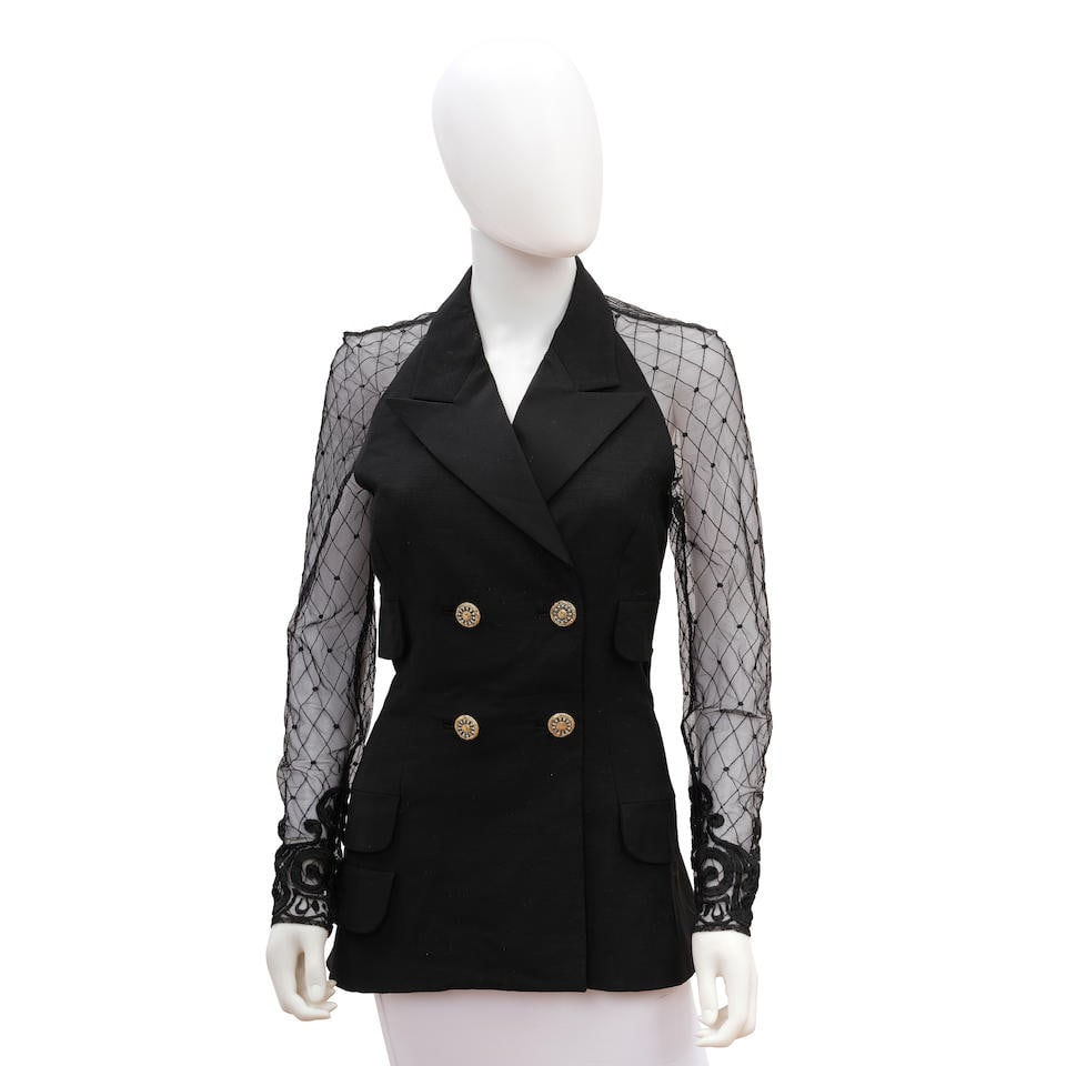 GIANNI VERSACE: BLACK LACE TRIM INSET BLAZER 1990'S: GIANNI VERSACE: BLACK LACE TRIM INSET BLAZER 1990'S • Size 38 Footnotes: OVERALL CONDITION: Excellent | No visible flaws. The Condition Report represents Bonhams' reasonable opinion as to the Lo