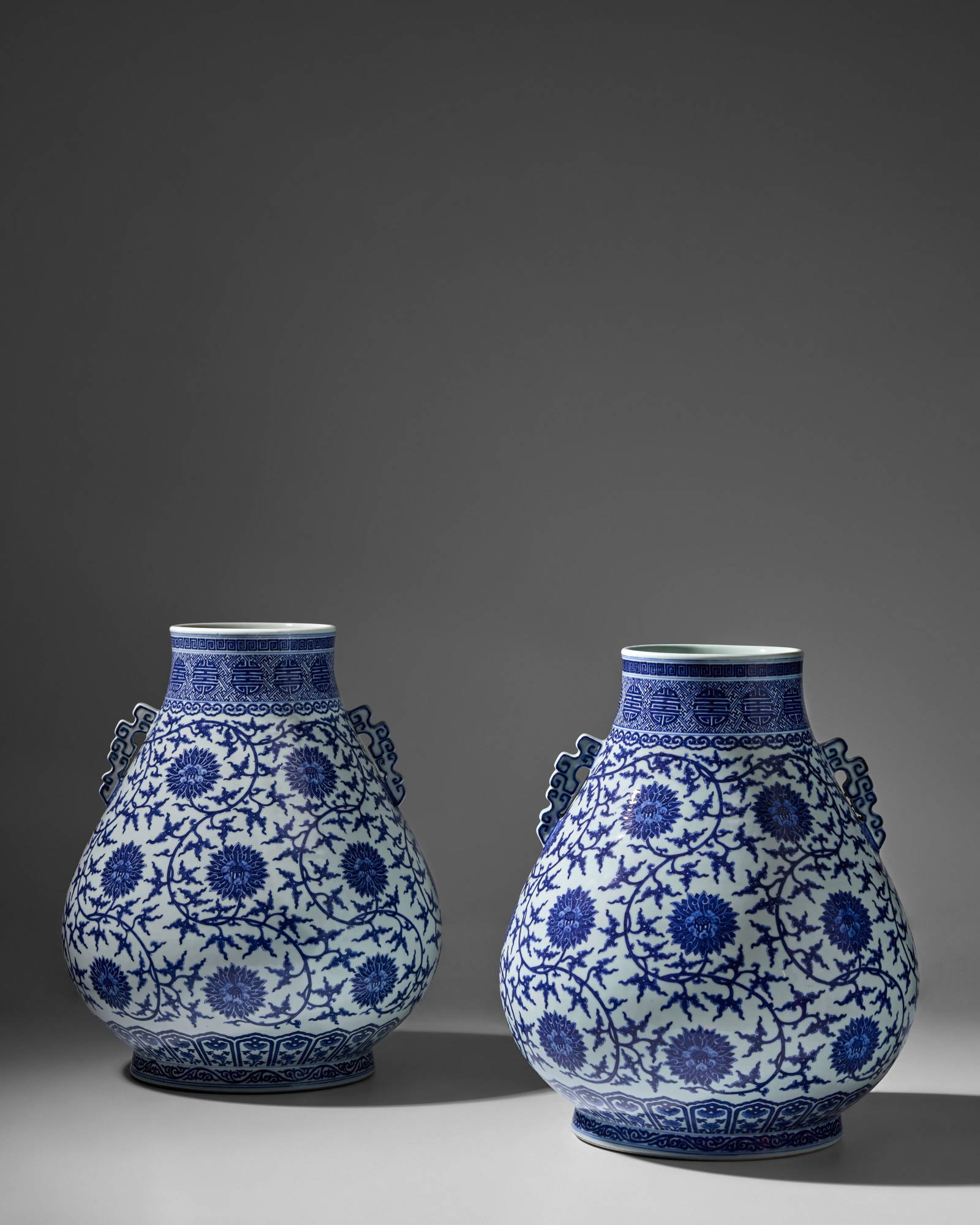 TWO IMPRESSIVE BLUE AND WHITE 'LOTUS AND SHOU-MEDALLION' HU-SHAPED HANDLED VASES Qianlong six-ch...