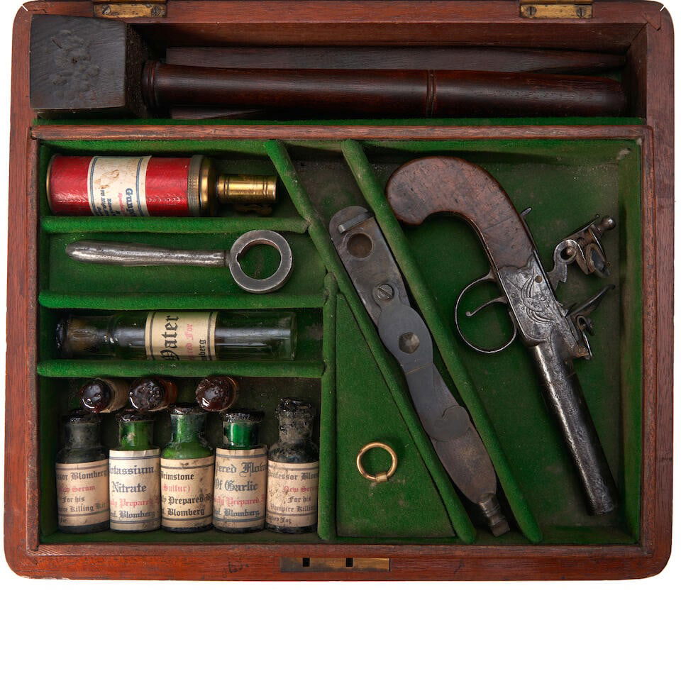 PROFESSOR BLOMBERG'S VAMPIRE KILLING KIT,: PROFESSOR BLOMBERG'S VAMPIRE KILLING KIT, likely 20th century. Mahogany case opening to a compartmented and green baize lined tray with an English flintlock pocket pistol, shot mold, powder flask, bar