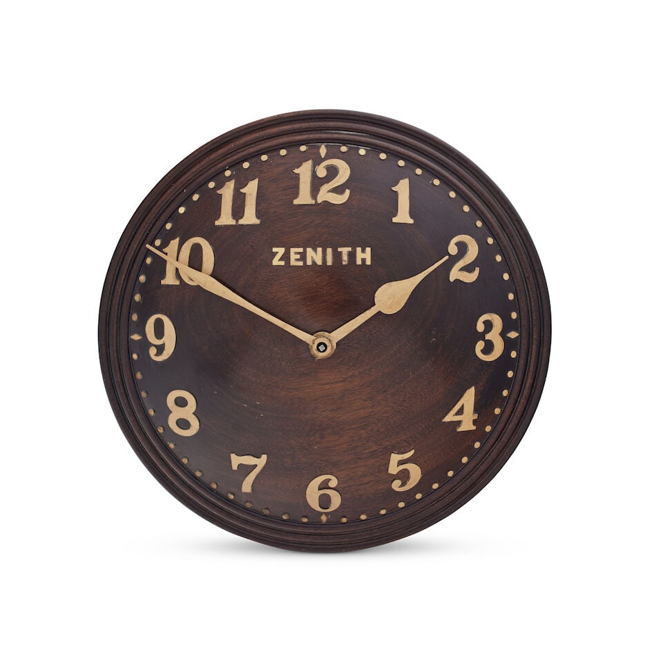 An early 20th century gilt brass and mahogany wall clock Zenith: An early 20th century gilt brass and mahogany wall clock Zenith The 13-inch dial of convex circular form with moulded border with Arabic numerals within a border of minute and five minute dot markers,
