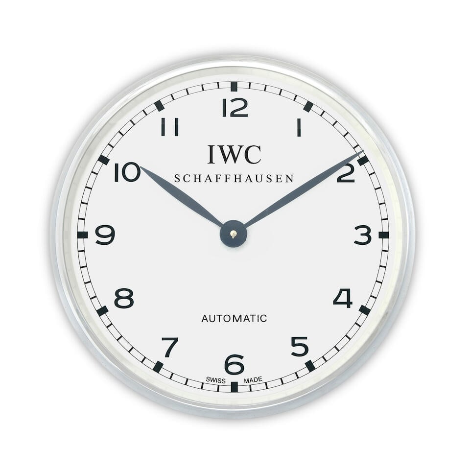 IWC. A plastic and stainless steel wall clock Circa 2010: IWC. A plastic and stainless steel wall clock Date: Circa 2010 Movement: Jewelled quartz Dial: White Case: Brushed and polished round Signed: Dial Size: 35cm For further information on this lot please
