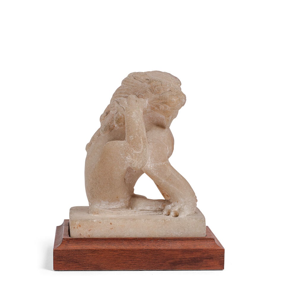 A SMALL MARBLE CARVED SEATED LION Tang-style (wood base)