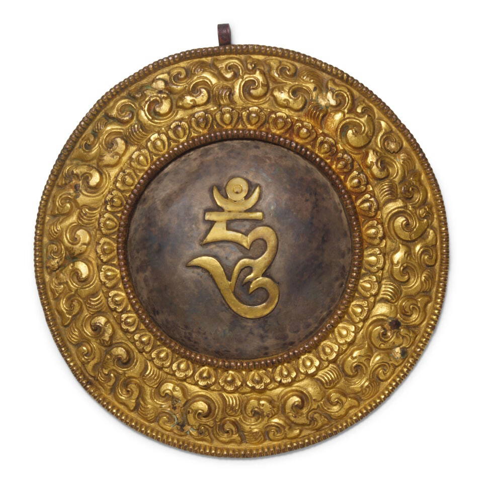 A STEEL AND GILT-COPPER ALLOY REPOUSSÉ ORACLE MIRROR Tibet, 18th Century