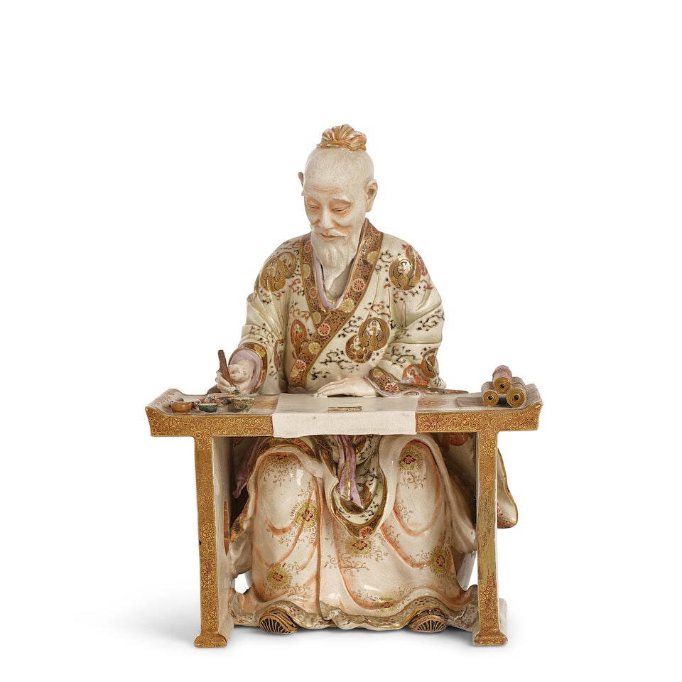 A JAPANESE GILT POLYCHROME SATSUMA FIGURE OF A CHINESE SCHOLAR AT HIS DESK Meiji era (1868-1912)...