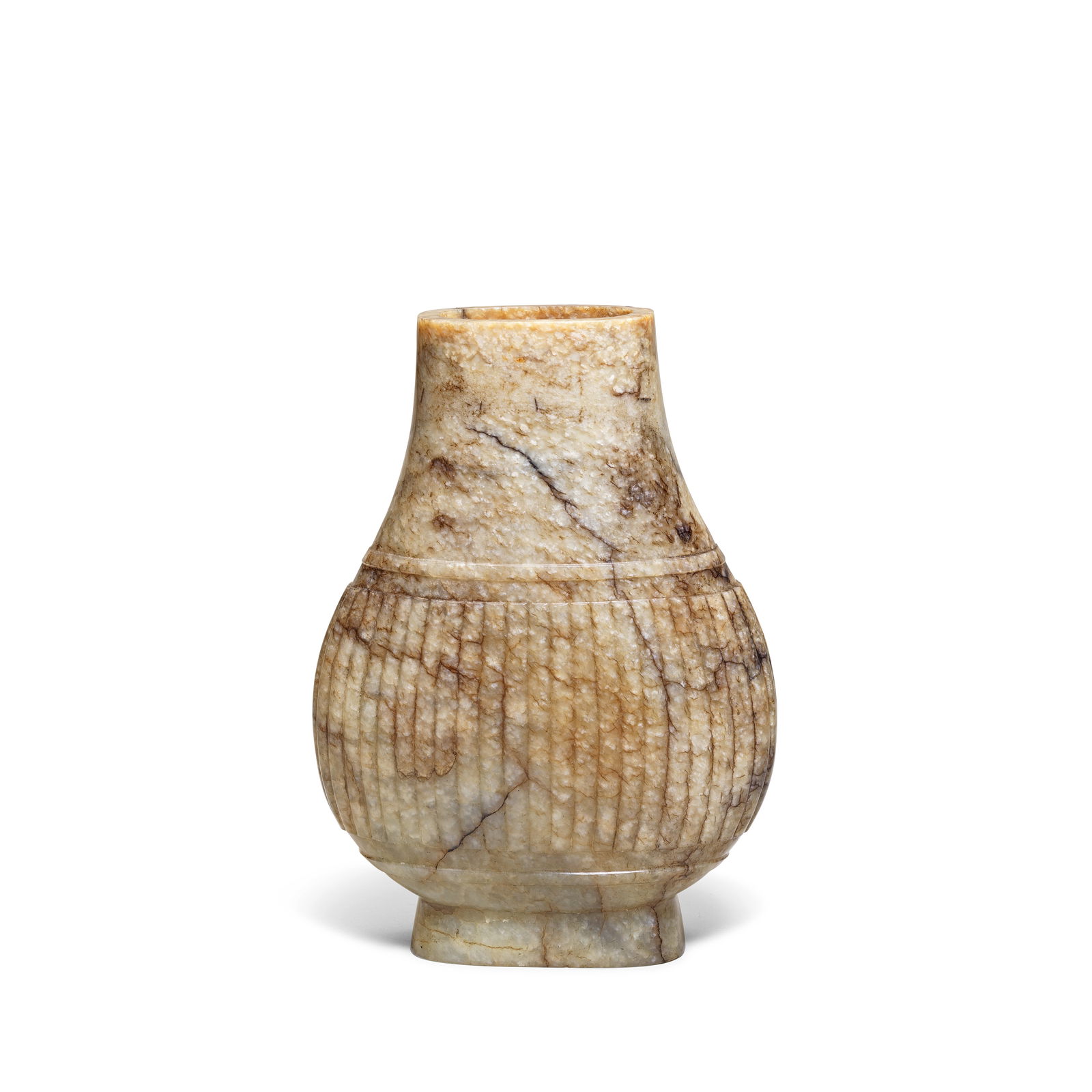 AN ARCHAISTIC JADE VASE, HU Ming Dynasty: AN ARCHAISTIC JADE VASE, HU Ming Dynasty Of compressed form, rising from a flared foot, the main body carved with a band of moulded vertical ribs, the stone of greyish beige tone with russet and black