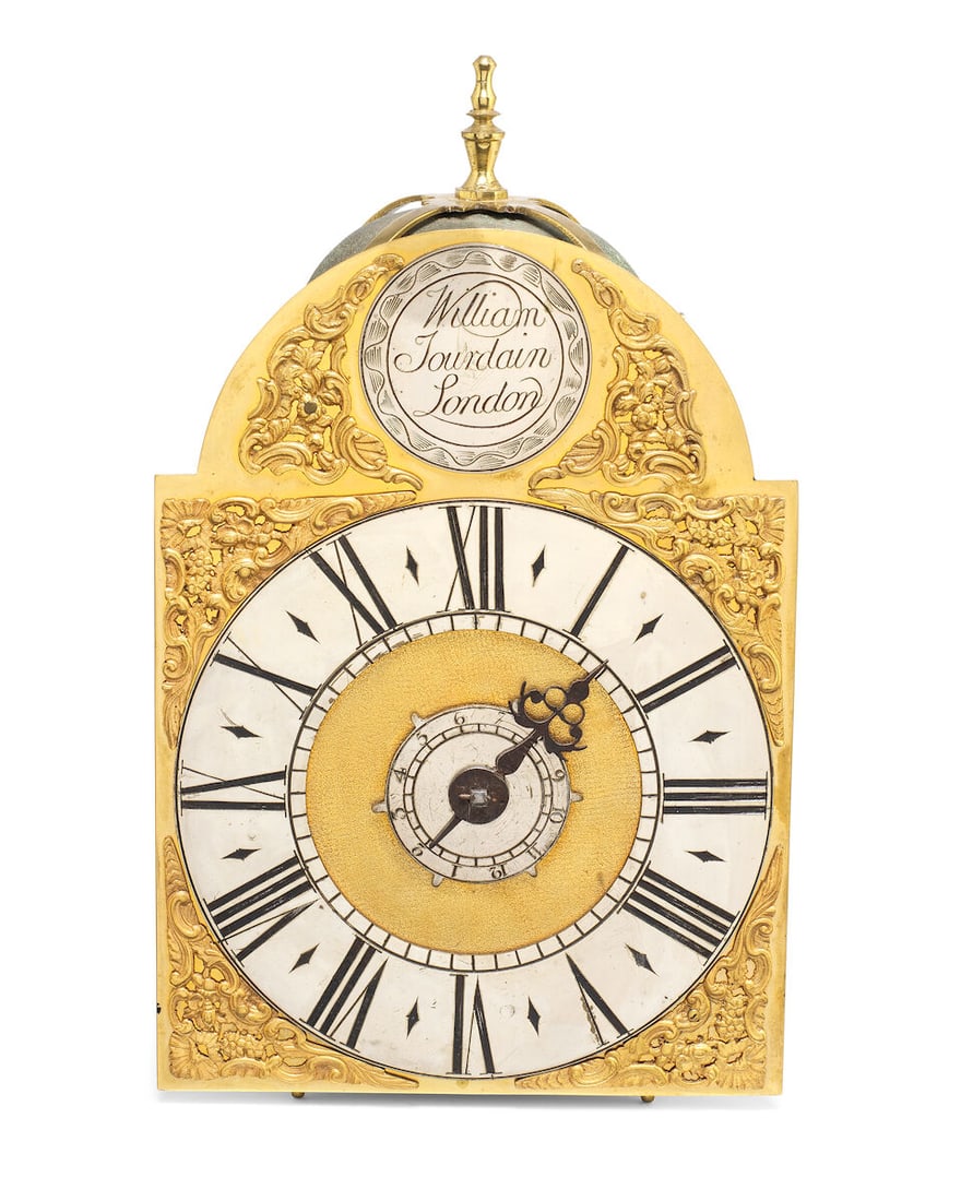 A mid 18th century small brass posted-frame weight driven striking wall clock with alarm Willia...: A mid 18th century small brass posted-frame weight driven striking wall clock with alarm William Jourdain, London The case surmounted by a strapped bell (the bell with indistinct casting mark) flanked