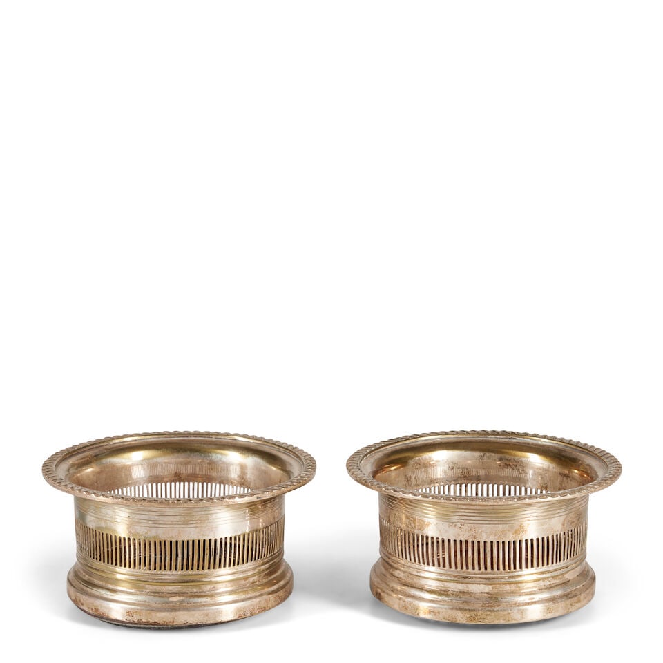 PAIR OF SILVER-PLATED WINE COASTERS 19th/20th century,: PAIR OF SILVER-PLATED WINE COASTERS 19th/20th century, Each with a pierced gallery and fitted with a turned wooden base, ht. 3 1/4, dia. 6 1/4 in. Footnotes: OVERALL CONDITION: Wear consistent with ag