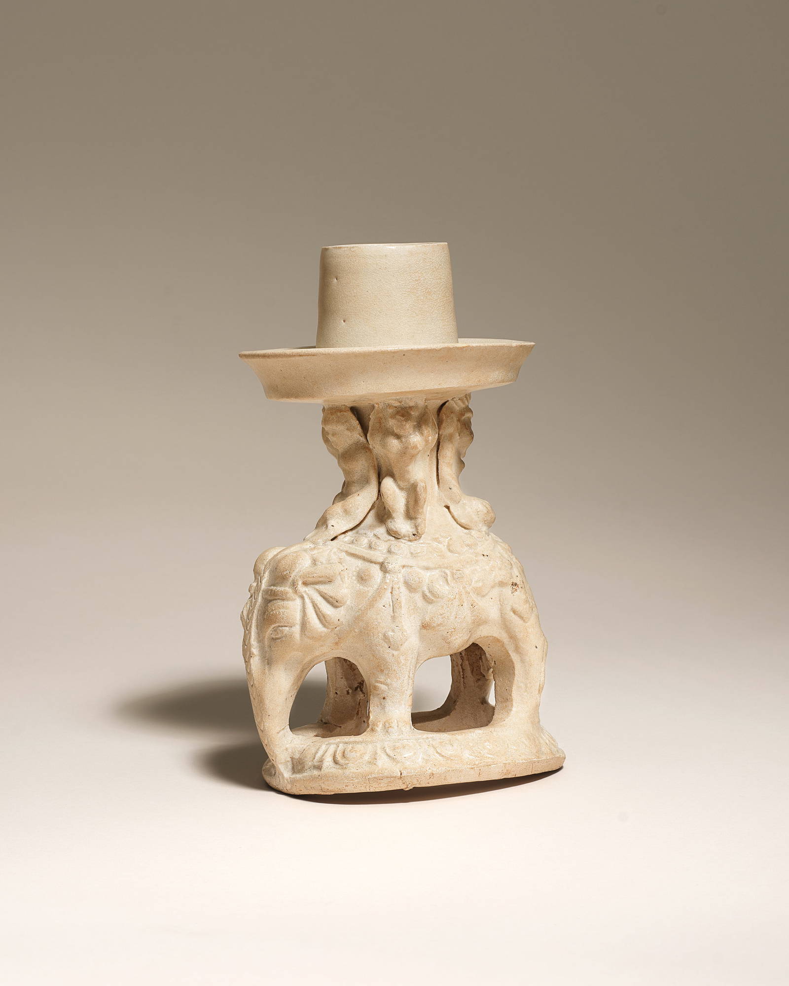 A RARE WHITE-GLAZED POTTERY ELEPHANT-SHAPED CANDLE-HOLDER Early Tang Dynasty, 7th century (2)