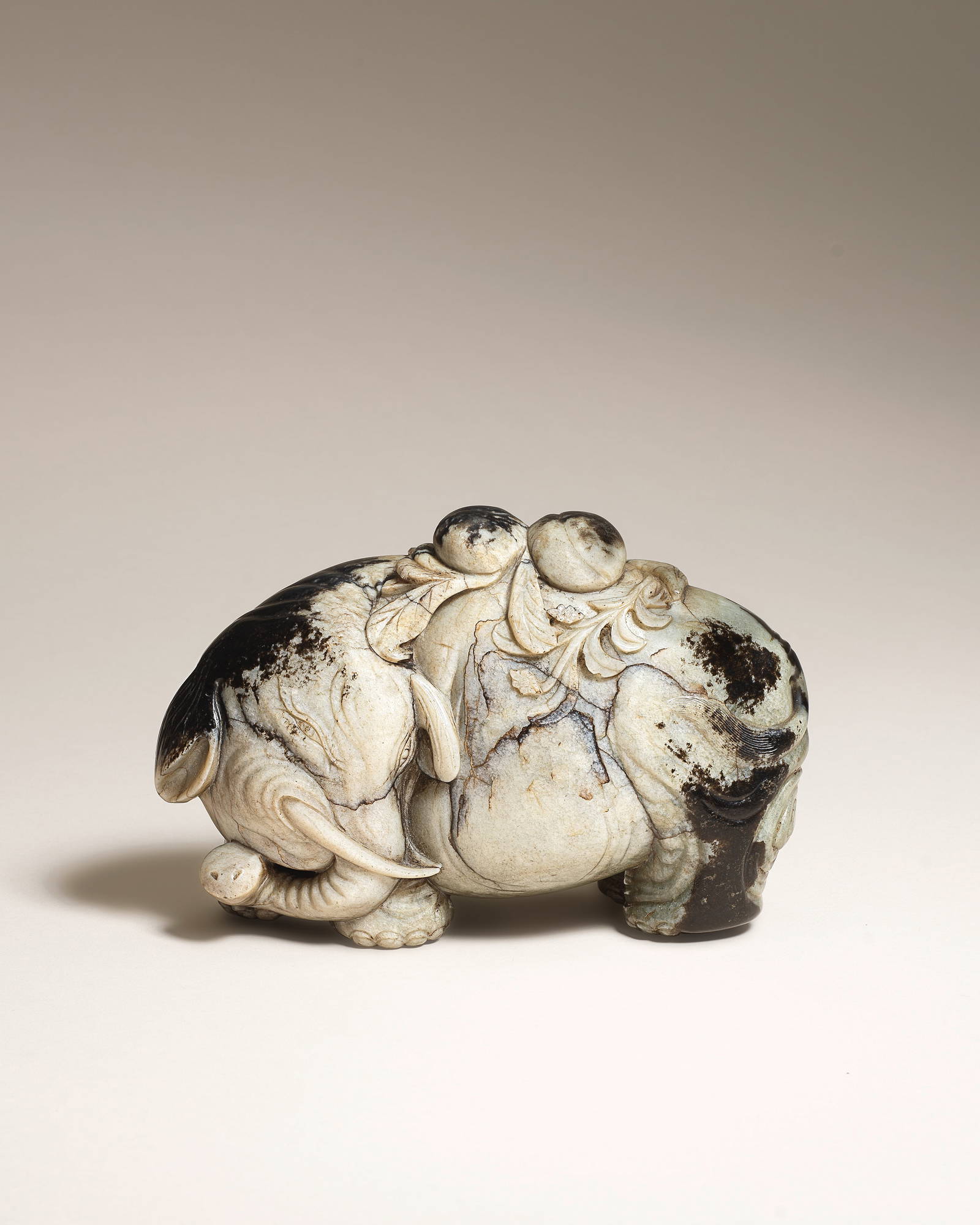 A FINE BLACK AND GREY JADE CARVING OF AN ELEPHANT CARRYING PEACHES 17th century (2)