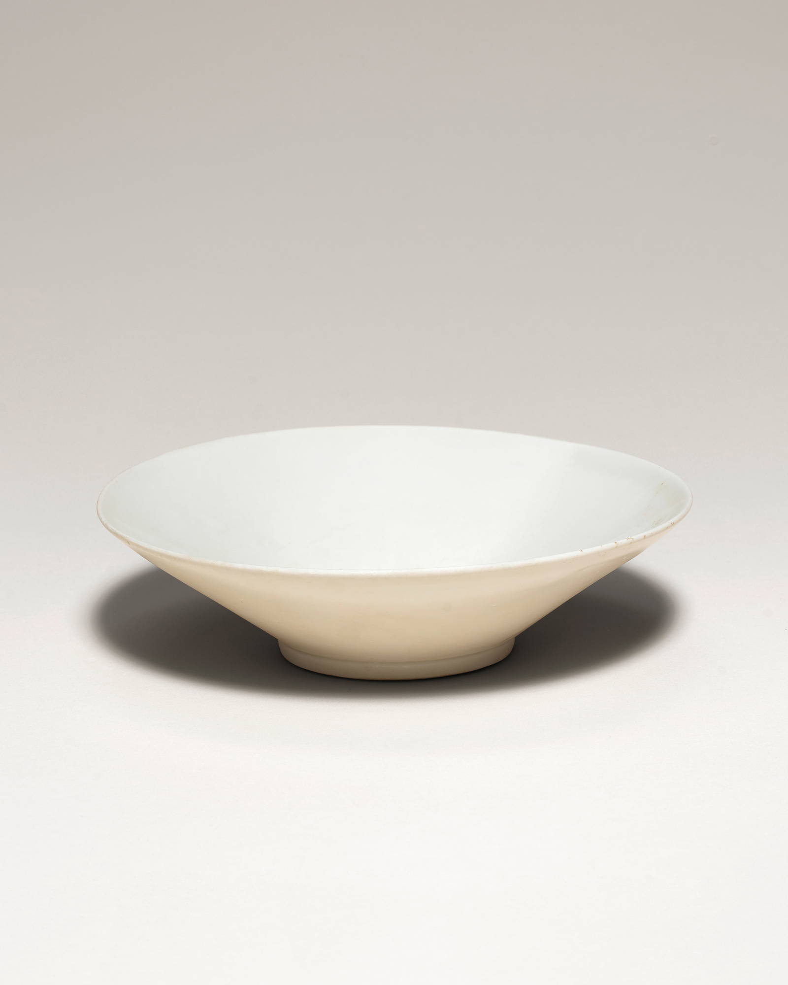 A DINGYAO WHITE-GLAZED SHALLOW BOWL Guan incised character, Five Dynasties/early Northern Song D...