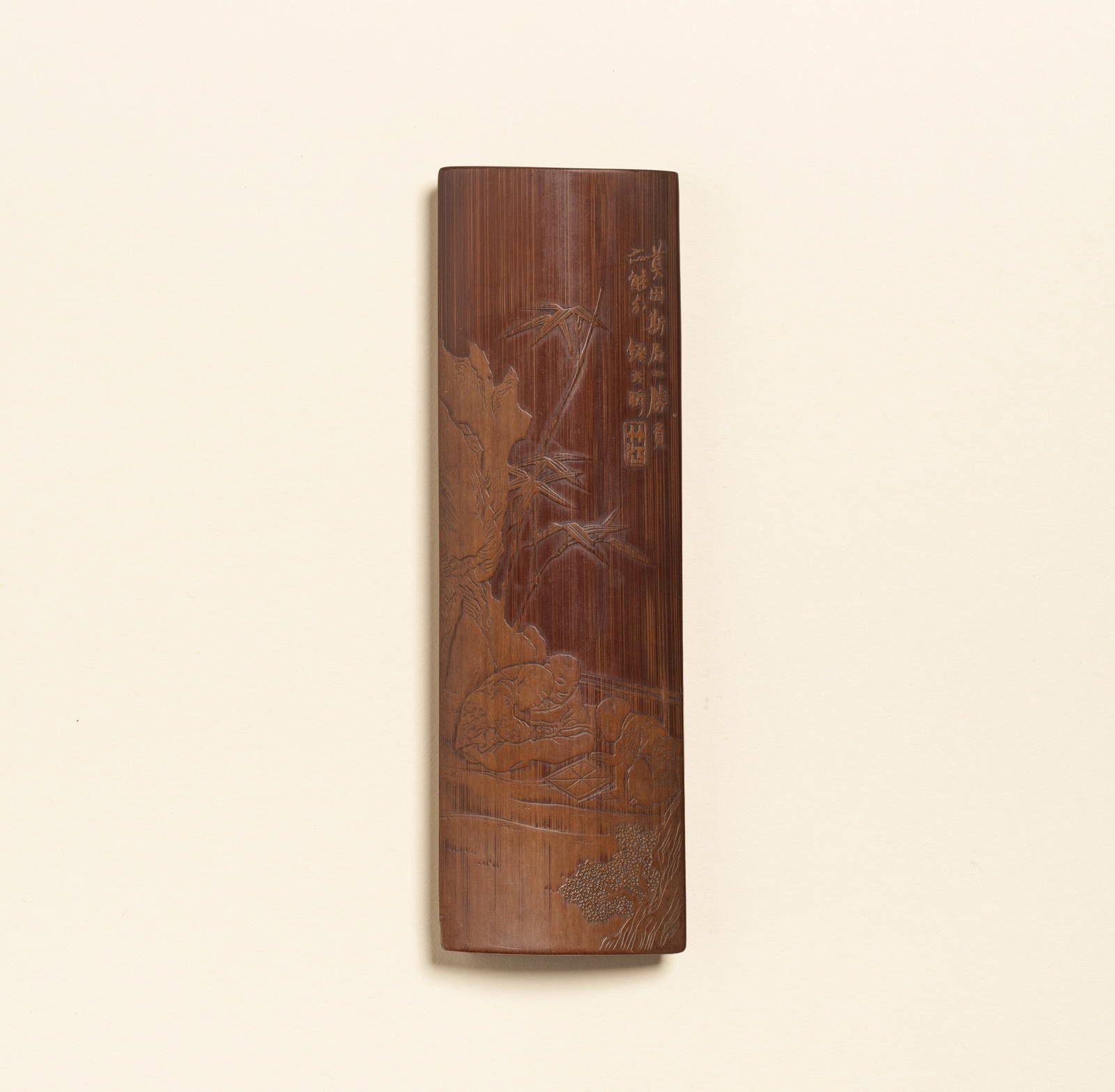 A CARVED BAMBOO 'LIUQING' 'BOYS AT PLAY' WRISTREST Signed Qian Daxin (1728-1804), Qianlong/Jiaqing