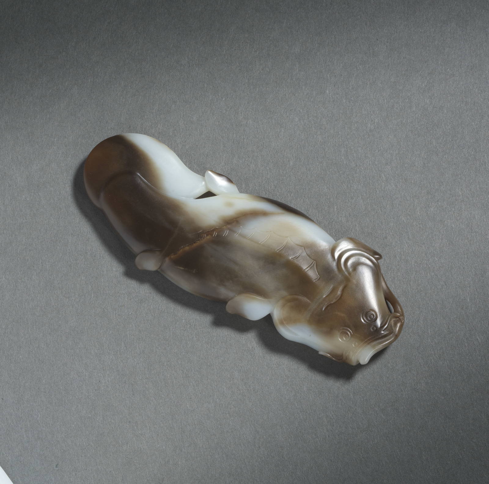 A SUPERB WHITE AND CHESTNUT-BROWN AGATE CATFISH SCROLL WEIGHT 18th century