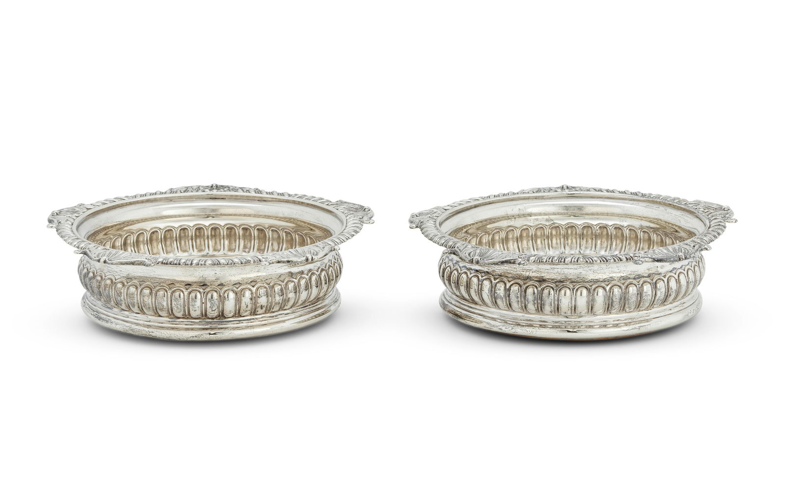 A pair of George III silver wine coasters William Burwash and Richard Sibley, London 1809 (2): A pair of George III silver wine coasters William Burwash and Richard Sibley, London 1809 Of typical form with shell and gadrooned borders leading to lobed bodies, the underside of bases with wood in