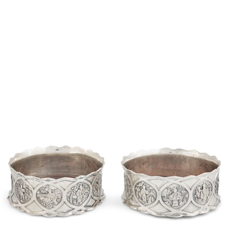 A Pair of Chinese Export Silver Bottle Stands China, mid-19th century: A Pair of Chinese Export Silver Bottle Stands China, mid-19th century Each cast silver ring with outer border of ten medallions depicting figural scenes, the order and composition details slightly var