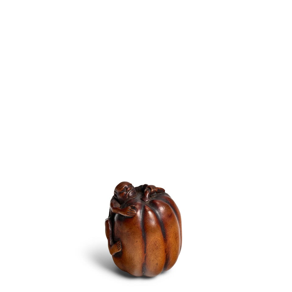 ARTIST UNKNOWN A Wood Netsuke of a Man on a Giant Pumpkin Edo period (1615-1868), 19th century