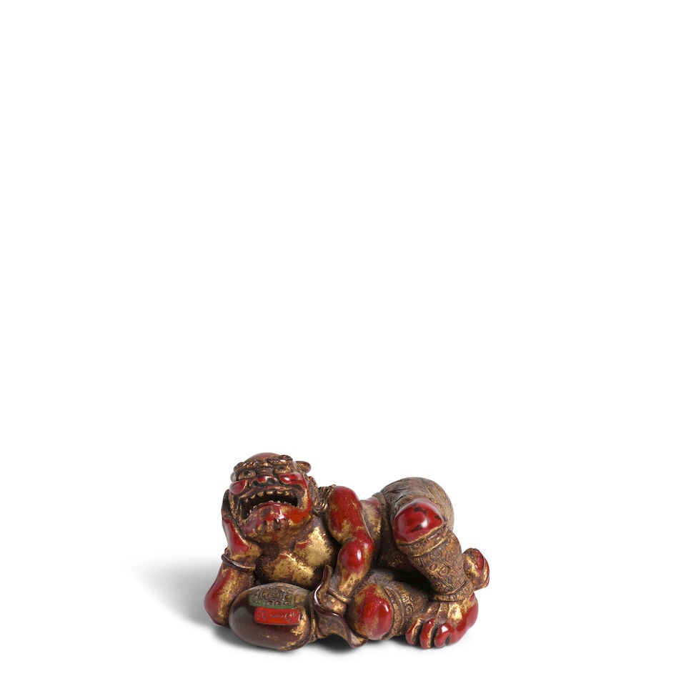 YŪSŌ (ACTIVE EARLY 20TH CENTURY) A Lacquered-Wood Netsuke of an Oni (Demon) with a Too...