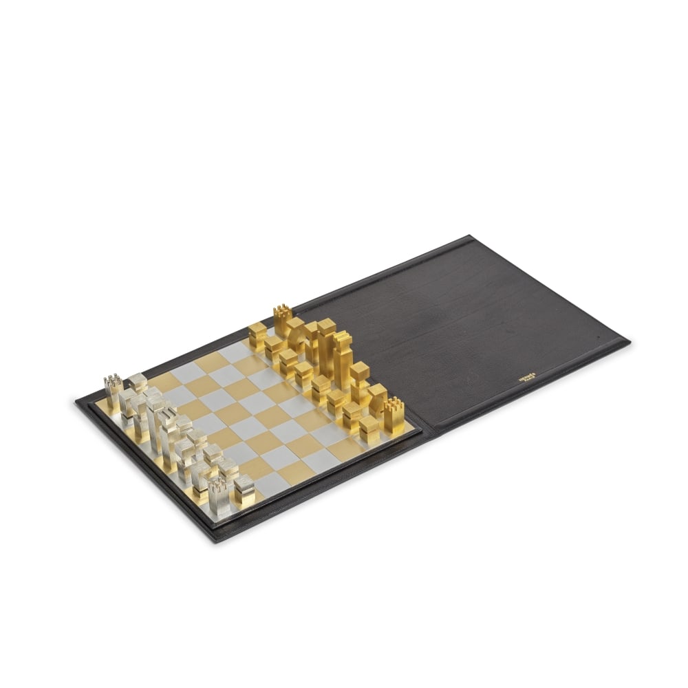 Hermès par Rena Dumas, circa 1985. Jeu d'échec en laiton et acier dans un étui en...: Hermès par Rena Dumas, circa 1985. Jeu d'échec en laiton et acier dans un étui en cuir de chèvre noir. Hermès by Rena Dumas, circa 1985. Chess set in brass and steel in a blac