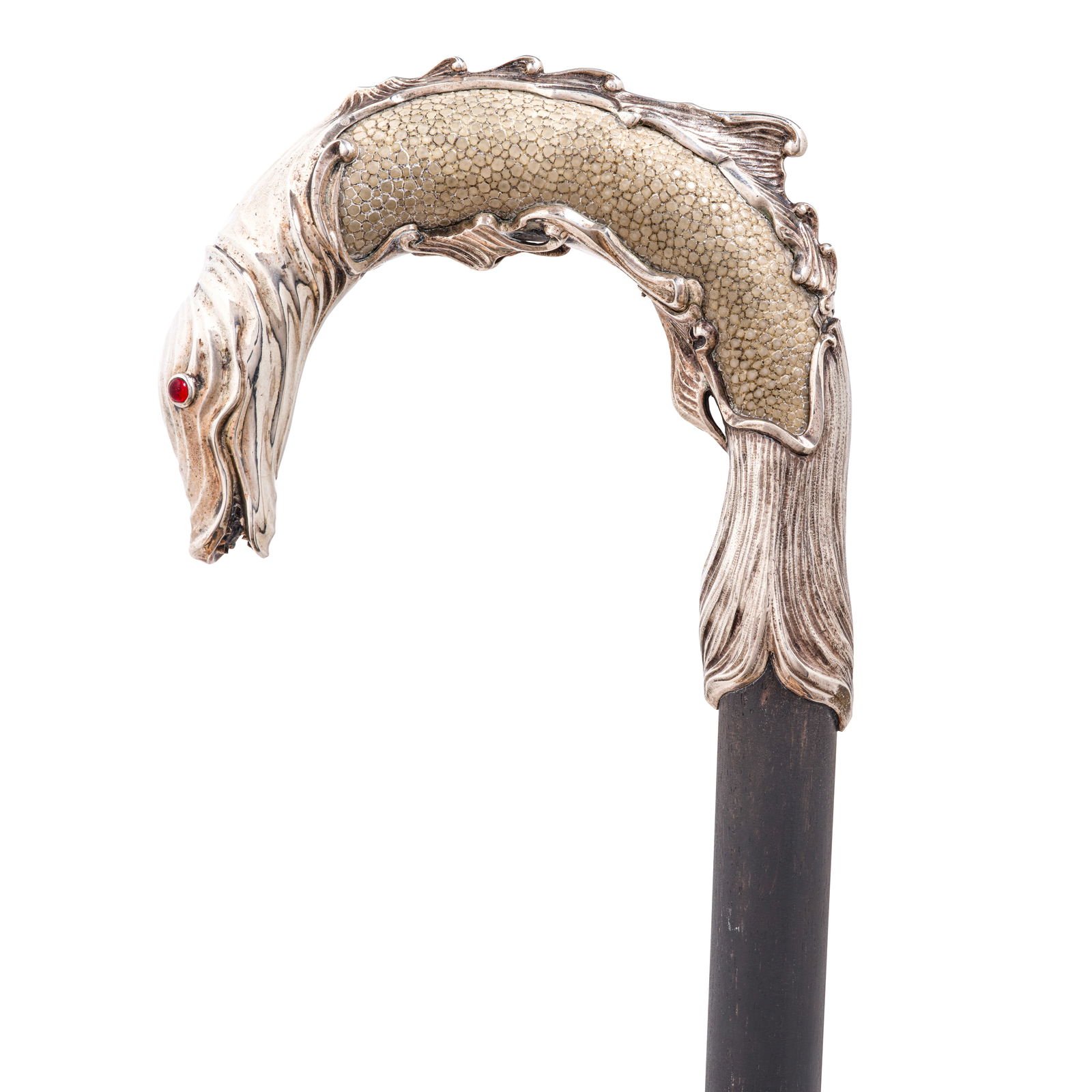 AN ENGLISH RUBY BOHEMIAN GLASS INSET SILVER OVERLAY SHAGREEN SEA SERPENT CANEDesigned and execut...: AN ENGLISH RUBY BOHEMIAN GLASS INSET SILVER OVERLAY SHAGREEN SEA SERPENT CANE Designed and executed by John Paul Cooper, London, 1921 The shagreen crook handle overlaid with heavy silver in the form o