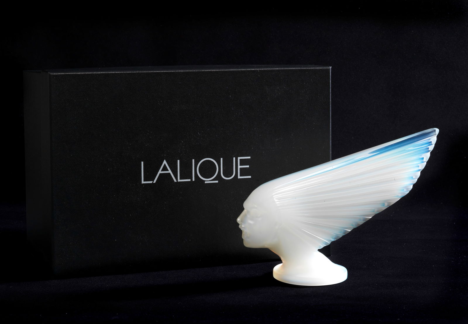 A boxed 'Victoire' glass mascot/deskpiece in opalescent glass by Lalique, French, post-War,: A boxed 'Victoire' glass mascot/deskpiece in opalescent glass by Lalique, French, post-War, engraved 'Lalique ® France' and numbered 'AB006' under the base, in white/blue opalescent glass, 25cm l