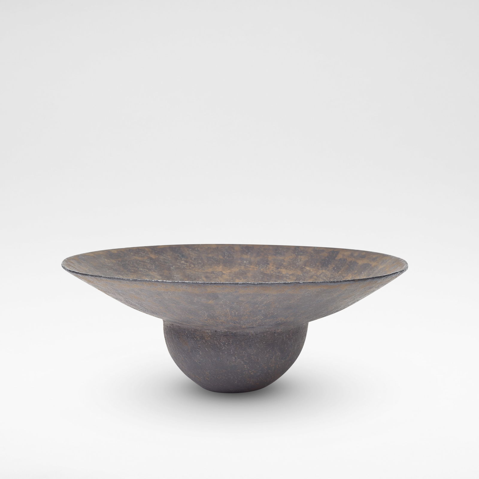 John Ward Flared-rim bowl: John Ward Flared-rim bowl Stoneware, mottled black and brown glazes over a textured body, the flared rim with radiating glaze lines. 13.6 cm high, 36.5 cm diameter Underside impressed with artist's se