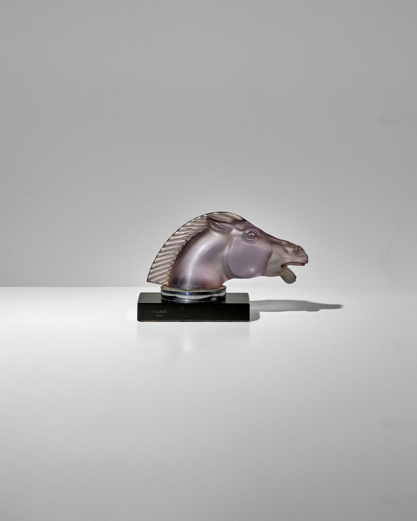 RENÉ LALIQUE (1860-1945) Epsom designed 1929 Marcilhac 1153, extraordinarily rare amethyst ...: RENÉ LALIQUE (1860-1945) Epsom designed 1929 Marcilhac 1153, extraordinarily rare amethyst tint, frosted glass, hand finished, molded mark 'R.LALIQUE FRANCE', on an original Vitrolite bookend bas