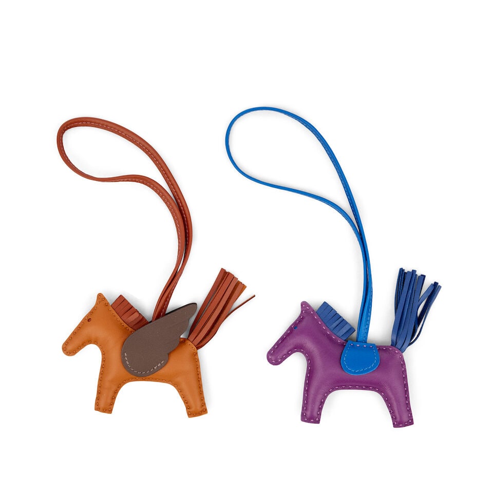 Hermès: Two Rodeo PM Charms (includes boxes): Hermès: Two Rodeo PM Charms To include a Pain d'Epice, Sienne and Moka Rodeo Pegase PM, 2024, and a Violet, Bleu France and Bleu Sapphir Rodeo PM, 2021, (2) Condition Grade A/A- Each