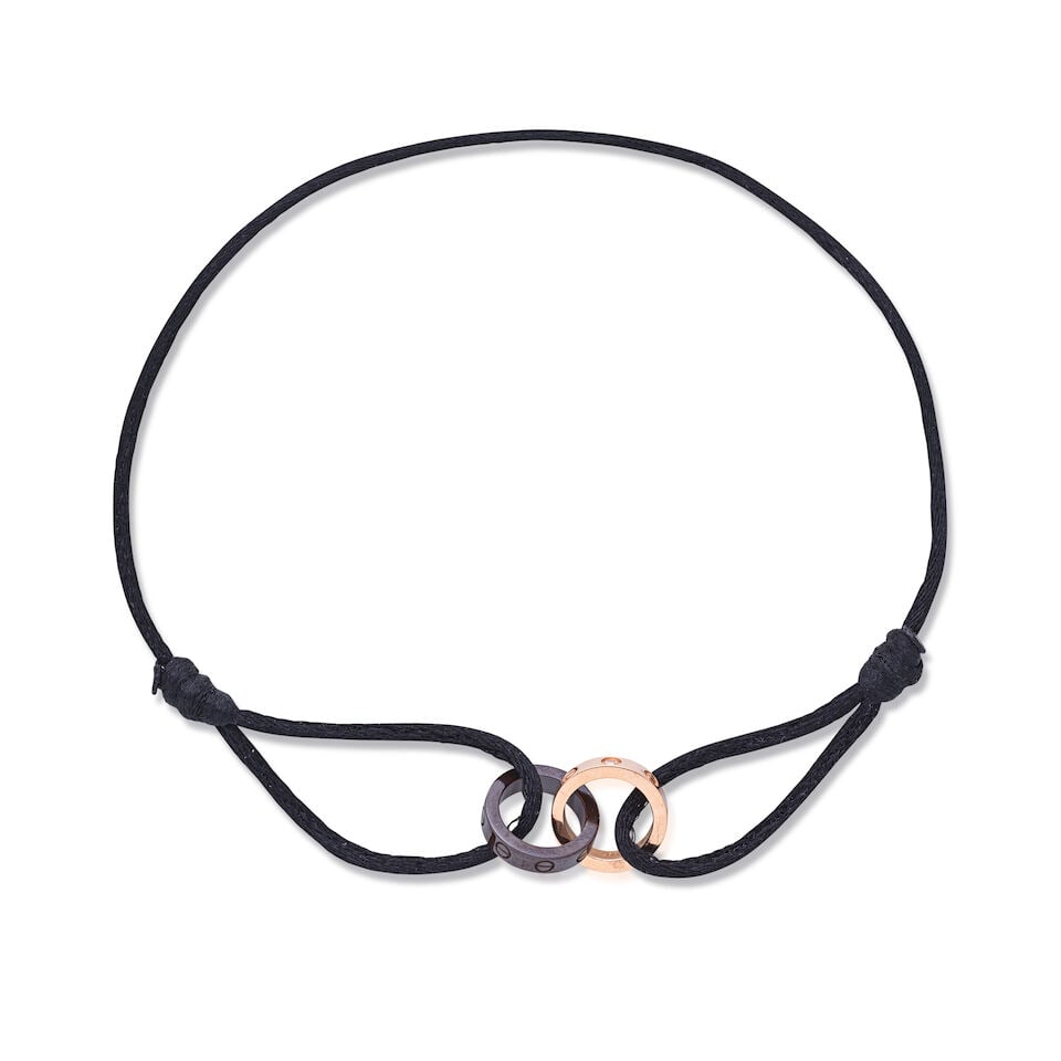 Cartier: a 18k Gold, Diamond and Ceramic Silk Cord Love Bracelet Purchased 2014 (includes pink s...: Cartier: a 18k Gold, Diamond and Ceramic Silk Cord Love Bracelet Purchased 2014 18k gold charm with 4 diamonds, a black ceramic charm on an adjustable silk cord Condition Grade A Diamonds