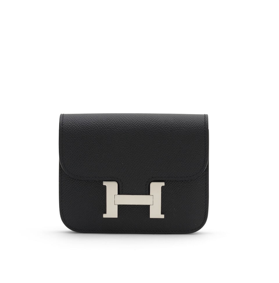 Hermès: a Black Epsom Leather Constance Slim Wallet 2025 (includes felt protector, dust bag...: Hermès: a Black Epsom Leather Constance Slim Wallet 2025 Wallet with belt buckle loop, together with a removable zipped pochette Condition Grade A+ 12.5cm wide, 10cm high, 2cm deep, pochette