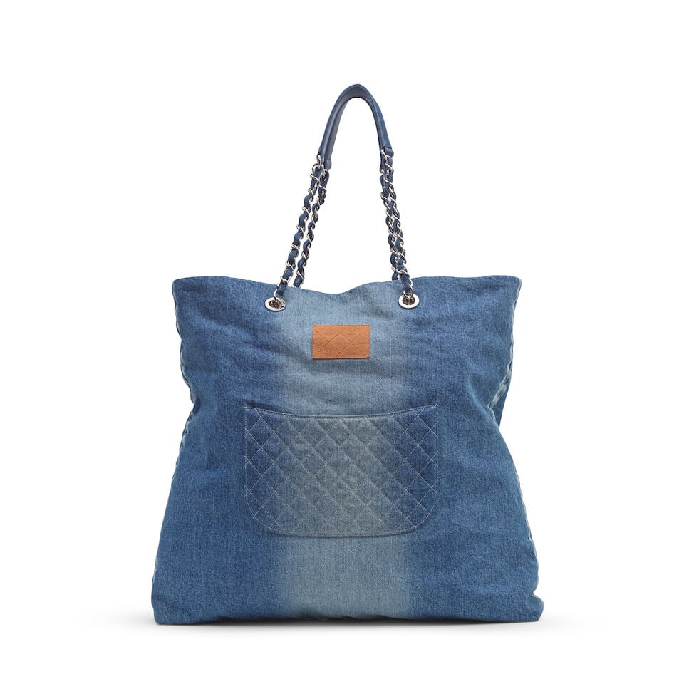 Chanel: a Denim Shoulder Bag and White Silk Camellia Brooch 2019 (includes authenticity card, se...: Chanel: a Denim Shoulder Bag and White Silk Camellia Brooch 2019 Creative Director: Karl Lagerfeld Blue gradient denim with printed chain detail to the sides and central leather plaque, silver tone