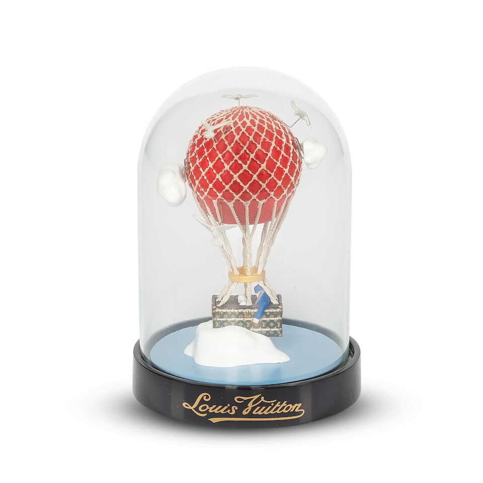 Louis Vuitton: a Malle Aéro Glass Dome 2013 (includes booklet and box): Louis Vuitton: a Malle Aéro Glass Dome 2013 Hot air balloon design in glass dome Condition Grade A 8cm wide, 12cm high, includes booklet and box Footnotes: The Air Balloon dome draws inspiration