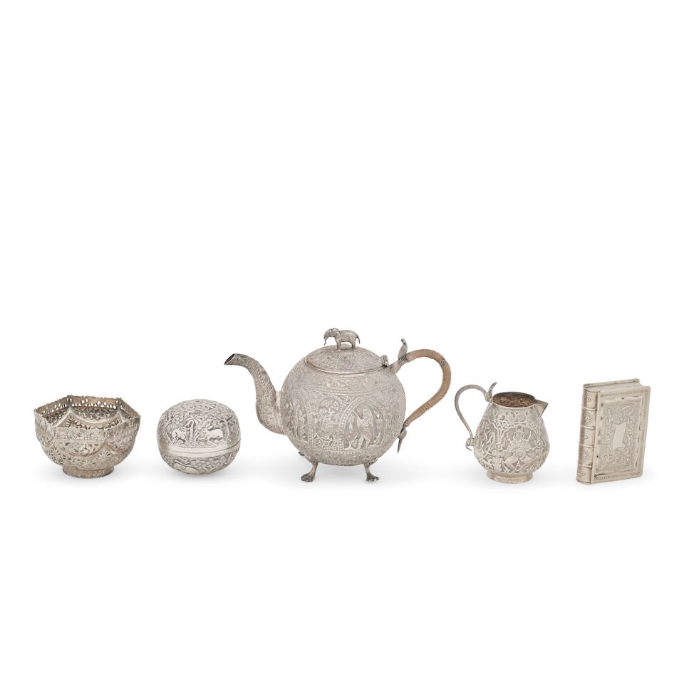An Indian silver teapot and milk jug, Circa 1900 (5): An Indian silver teapot and milk jug, Circa 1900 Of spherical form, chased with arch-shaped panels of deities and with foliate bands and elephant finial, a bun-shaped box, a hexagonal bowl and a