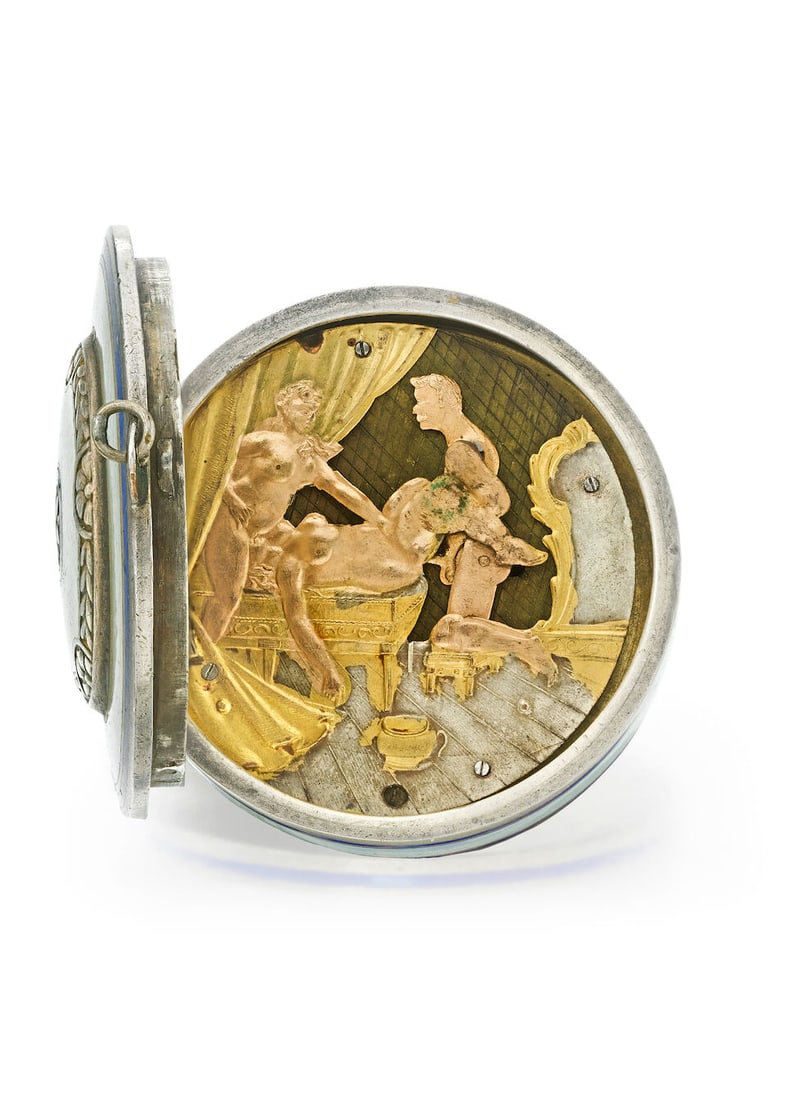 [NO RESERVE] A SILVER GILT, BLUE AND WHITE ENAMEL CONTINENTAL EROTIC AUTOMATONc. 1830s: [NO RESERVE] A SILVER GILT, BLUE AND WHITE ENAMEL CONTINENTAL EROTIC AUTOMATON Date: c. 1830s Movement: Gilt Dial: Silver, gilt and brass erotic scene with three figures Case: Round, translucent blue