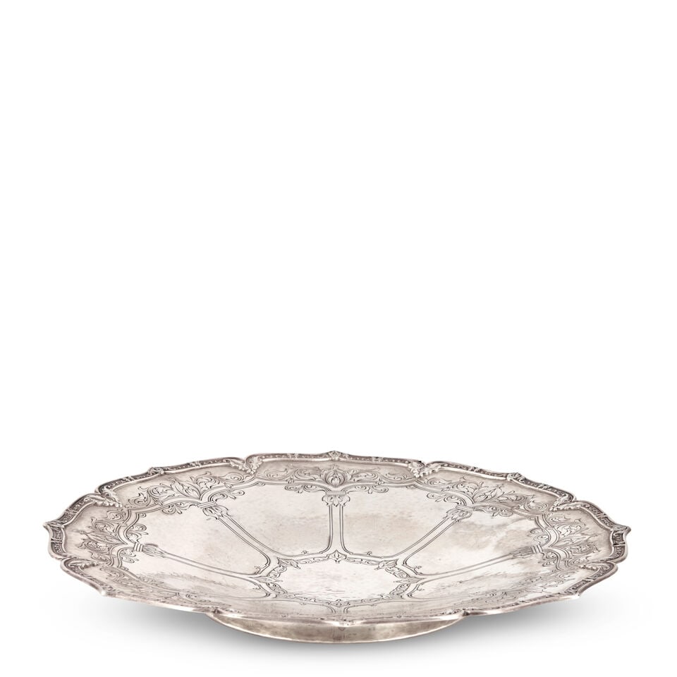LEBOLT STERLING SILVER LOW TAZZA Chicago, early 20th century, of shaped circular form, the well ...: LEBOLT STERLING SILVER LOW TAZZA Chicago, early 20th century, of shaped circular form, the well engraved with a scrolled foliate and architectural designed, on a short pedestal foot, dia. 10 1/2 in.,