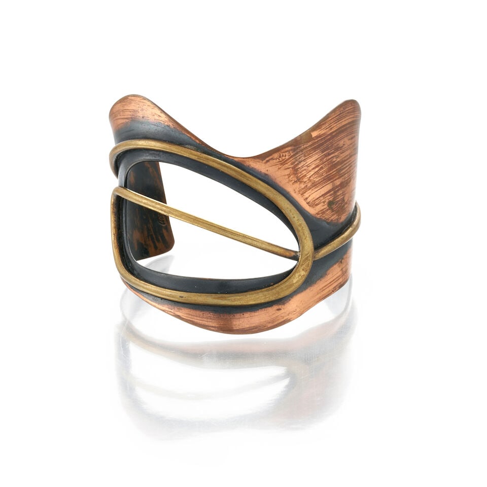 ART SMITH (1917-1982) COPPER AND BRASS CUFF BRACELET an open hole cuff in abstract form, signed ...: ART SMITH (1917-1982) COPPER AND BRASS CUFF BRACELET an open hole cuff in abstract form, signed Art Smith, interior circumference approximately 7 in. Footnotes: Art Smith (1917-1982) was one of