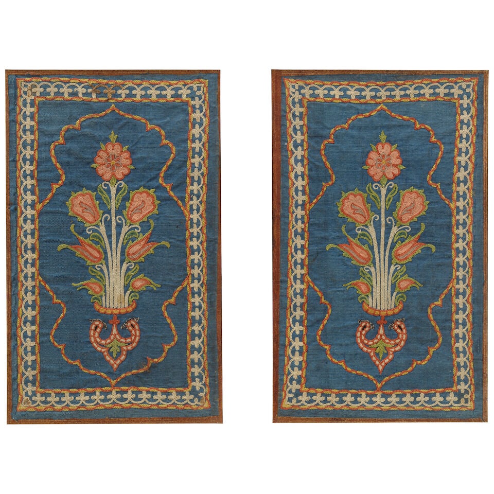 A pair of Safavid embroidered-silk-mounted leather bookbindings Persia, circa 1700: A pair of Safavid embroidered-silk-mounted leather bookbindings Persia, circa 1700 each of rectangular form, the leather boards mounted with blue silk embroidered in polychrome with medallions contain