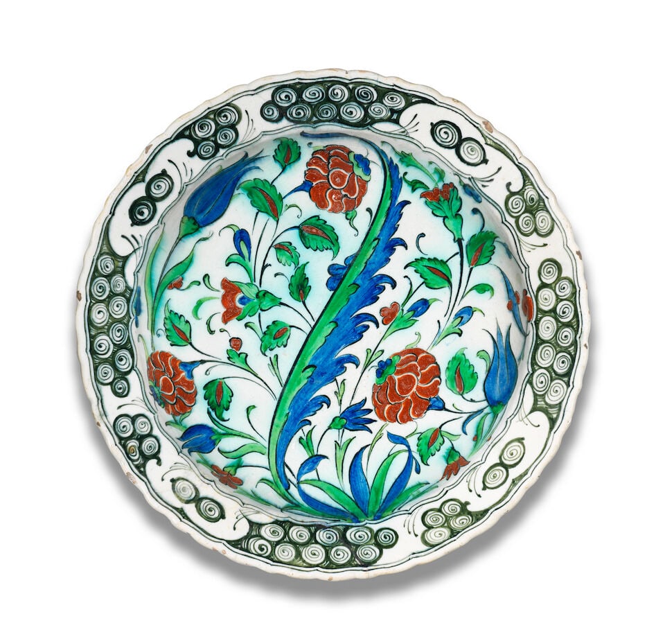 A large Cantagalli Iznik style pottery dish Italy, 19th Century: A large Cantagalli Iznik style pottery dish Italy, 19th Century of deep rounded form with scalloped rim decorated in cobalt blue, green, raised-red and black on a white ground with a central saz leaf 