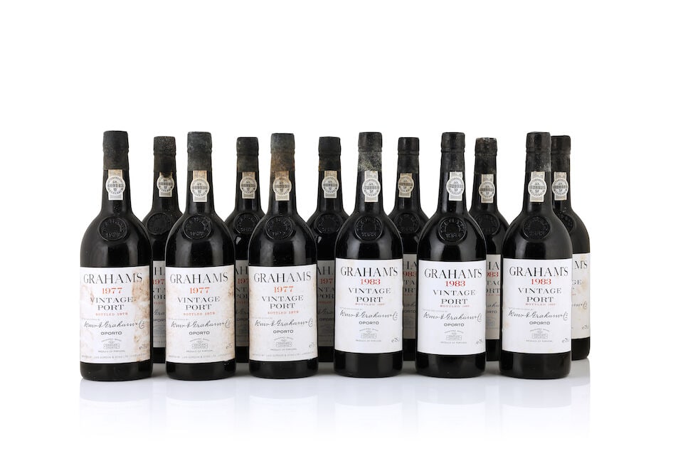 Graham's, 1977 (11 x 750ml) Graham's, 1983 (12 x 750ml): Graham's, 1977 (11 x 750ml) Region: Portugal Fill Level: 5 base of neck Capsule: corroded embossed lead capsule Label: badly bin-soiled & damp stained Packaging: original wooden case Graham's, 1983 (1