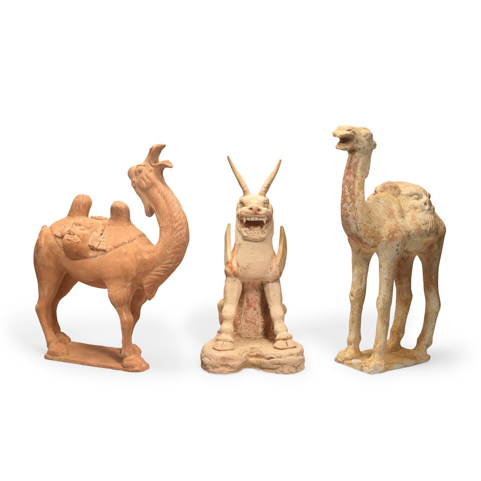 TWO TERRACOTTA MODELS OF CAPARISONED CAMELS AND A TERRACOTTA EARTH SPIRIT Probably Tang Dynasty... (1 of 2)