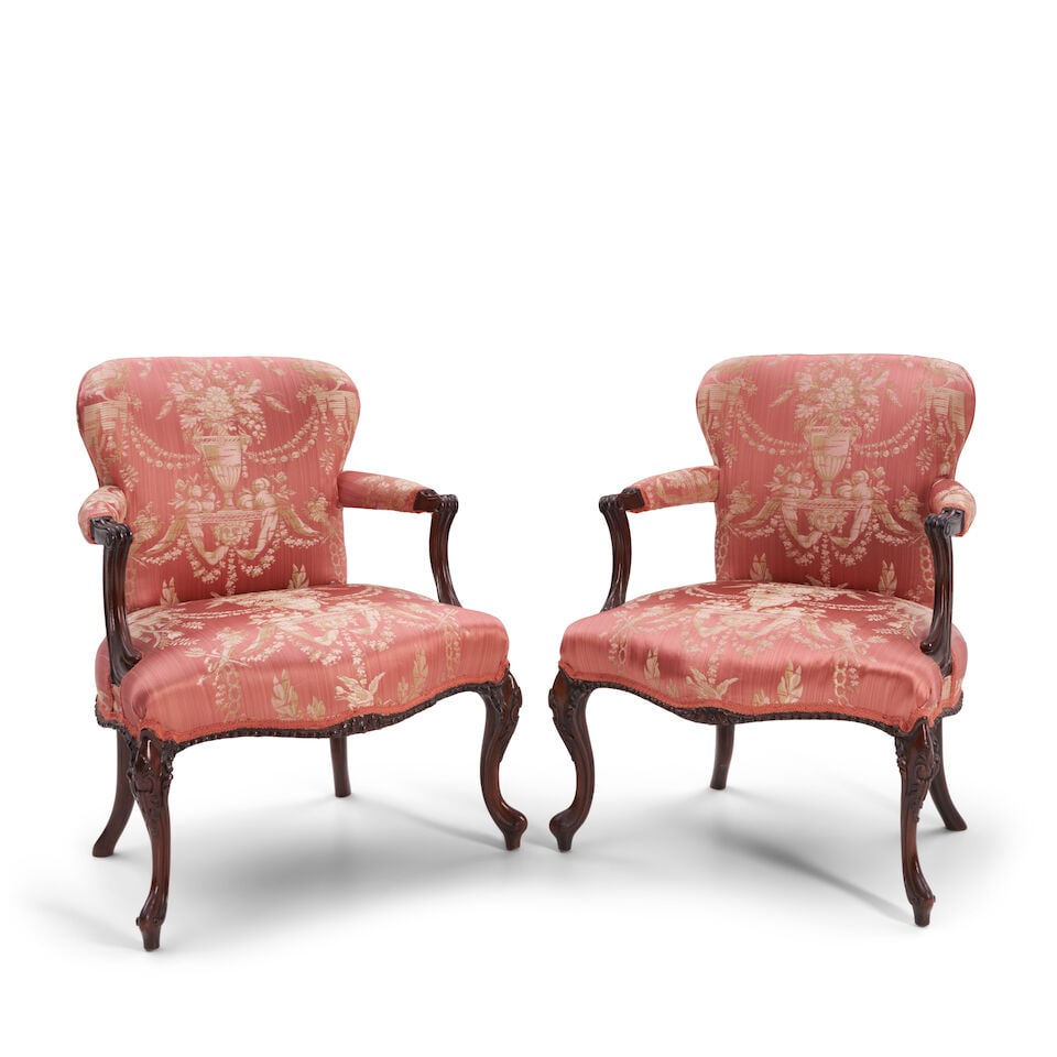 A Pair of George III Mahogany Armchairs, England, late 18th century: A Pair of George III Mahogany Armchairs, England, late 18th century in the French taste, upholstered and shaped back, seat and arms and with mahogany molded and voluted arm supports, molded cabriole f