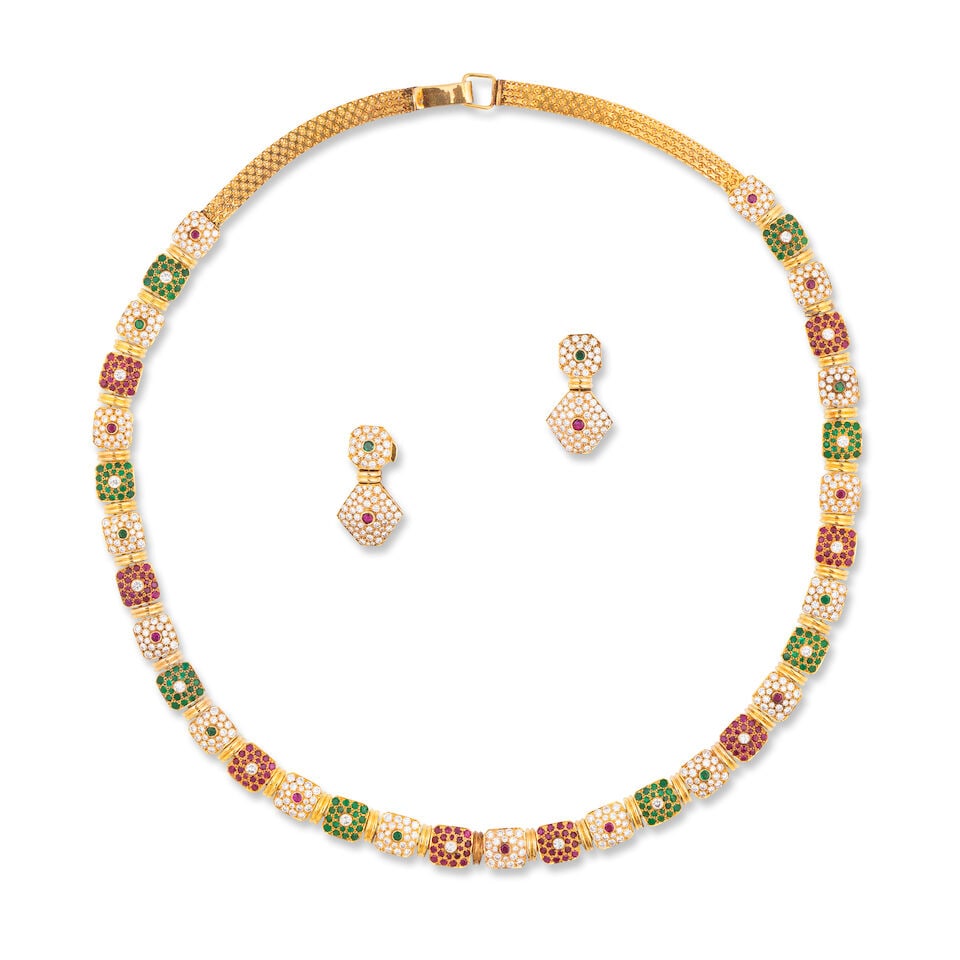 EMERALD, RUBY AND DIAMOND DEMI-PARURE DEMI-PARURE ÉMERAUDES, RUBIS ET DIAMANTS: EMERALD, RUBY AND DIAMOND DEMI-PARURE DEMI-PARURE ÉMERAUDES, RUBIS ET DIAMANTS • French import marks for 14 carat yellow gold (585 ‰) • Comprising a necklace and a pair of