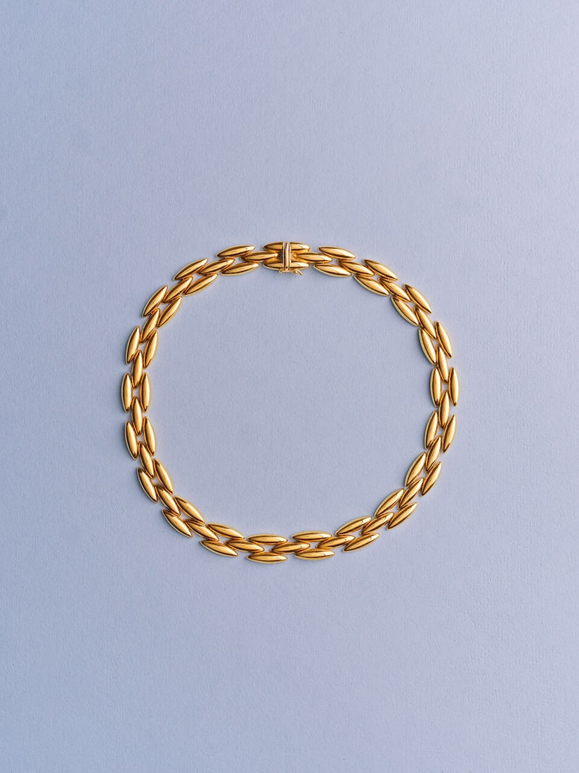 CARTIER: GOLD 'GENTIANE' NECKLACE CARTIER: COLLIER 'GENTIANE' EN OR: CARTIER: GOLD 'GENTIANE' NECKLACE CARTIER: COLLIER 'GENTIANE' EN OR • French import mark for 18 carat gold (750 ‰) • Articulated oval-shaped plaques • Italian maker's mark R