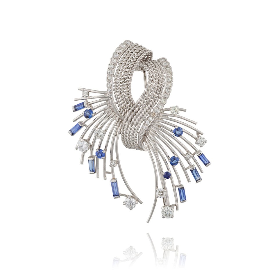 SAPPHIRE AND DIAMOND BROOCH BROCHE SAPHIRS ET DIAMANTS: SAPPHIRE AND DIAMOND BROOCH BROCHE SAPHIRS ET DIAMANTS • French import mark for 18 carat white gold (750 ‰) and for platinum (850 ‰) • Ribbon motif composed of gold filigree