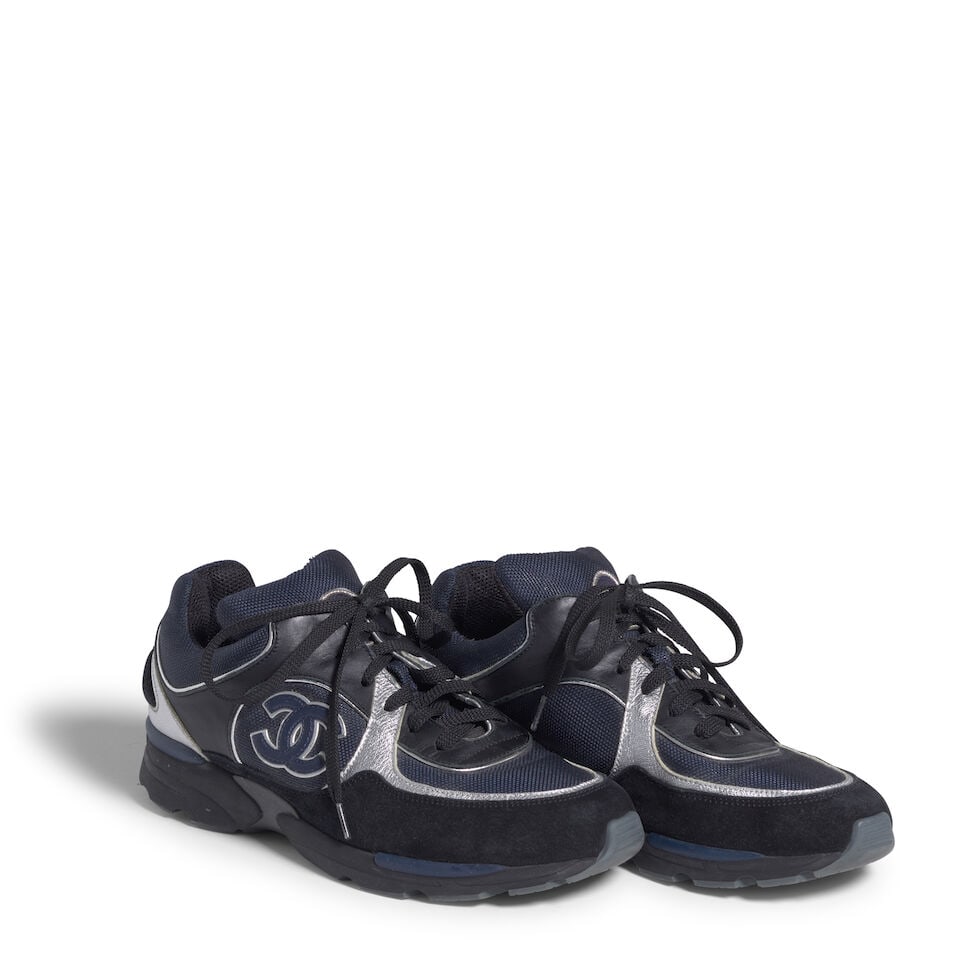 CHANEL: NAVY AND BLACK CONTRAST STITCH LOGO SNEAKERS: CHANEL: NAVY AND BLACK CONTRAST STITCH LOGO SNEAKERS • Marked Size 39 1/2 Footnotes: OVERALL CONDITION: Good | Wear throughout. The Condition Report represents Bonhams' reasonable opinion as to