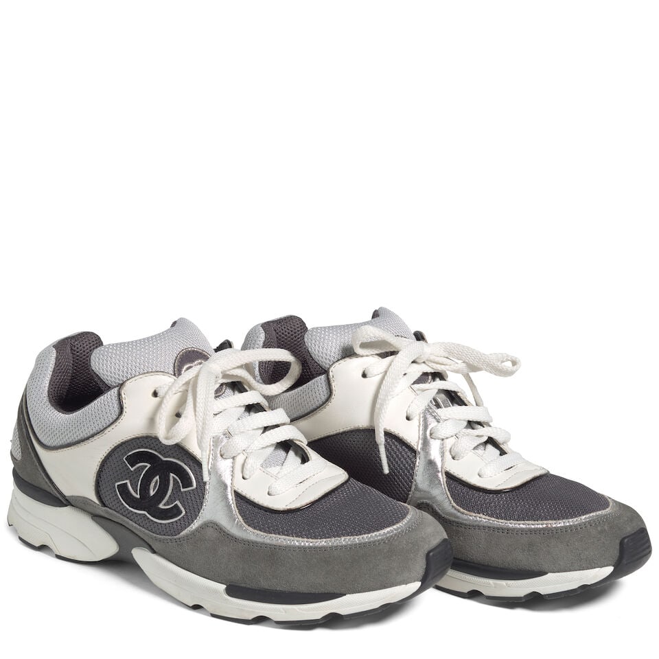CHANEL: GREY AND WHITE LOGO LEATHER SNEAKERS: CHANEL: GREY AND WHITE LOGO LEATHER SNEAKERS • Marked Size 39 1/2 Footnotes: OVERALL CONDITION: Good | Wear throughout. The Condition Report represents Bonhams' reasonable opinion as to the Lot'