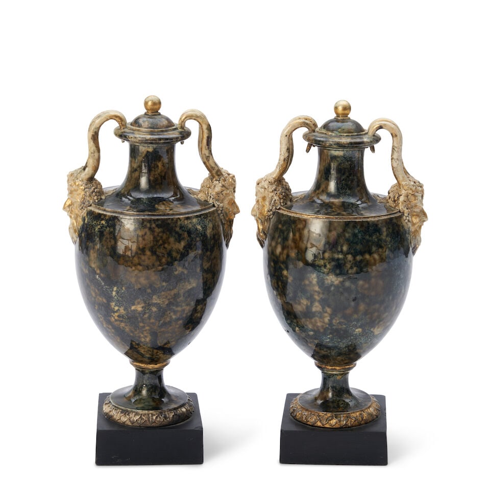Two Similar Wedgwood & Bentley Mottled Vases and Covers, England, c. 1770,: Two Similar Wedgwood & Bentley Mottled Vases and Covers, England, c. 1770, each with Bacchus mask and horn handles, and mounted atop a black basalt plinth, impressed mark, ht. 9 1/2, 9 5/8 in. Footnot