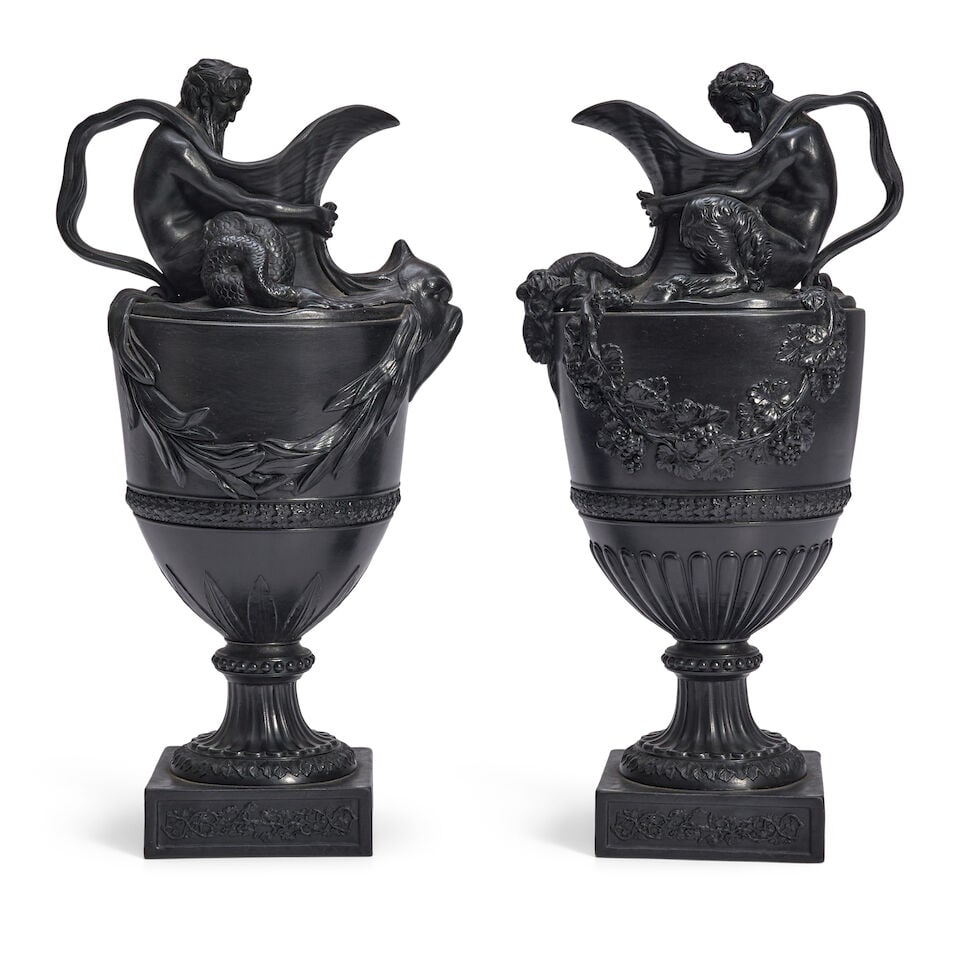 Pair of Wedgwood Black Basalt Wine and Water Ewers, England, 19th century,: Pair of Wedgwood Black Basalt Wine and Water Ewers, England, 19th century, the wine ewer modeled with a figure of Bacchus seated atop the shoulder and holding the horns of a ram's head below the