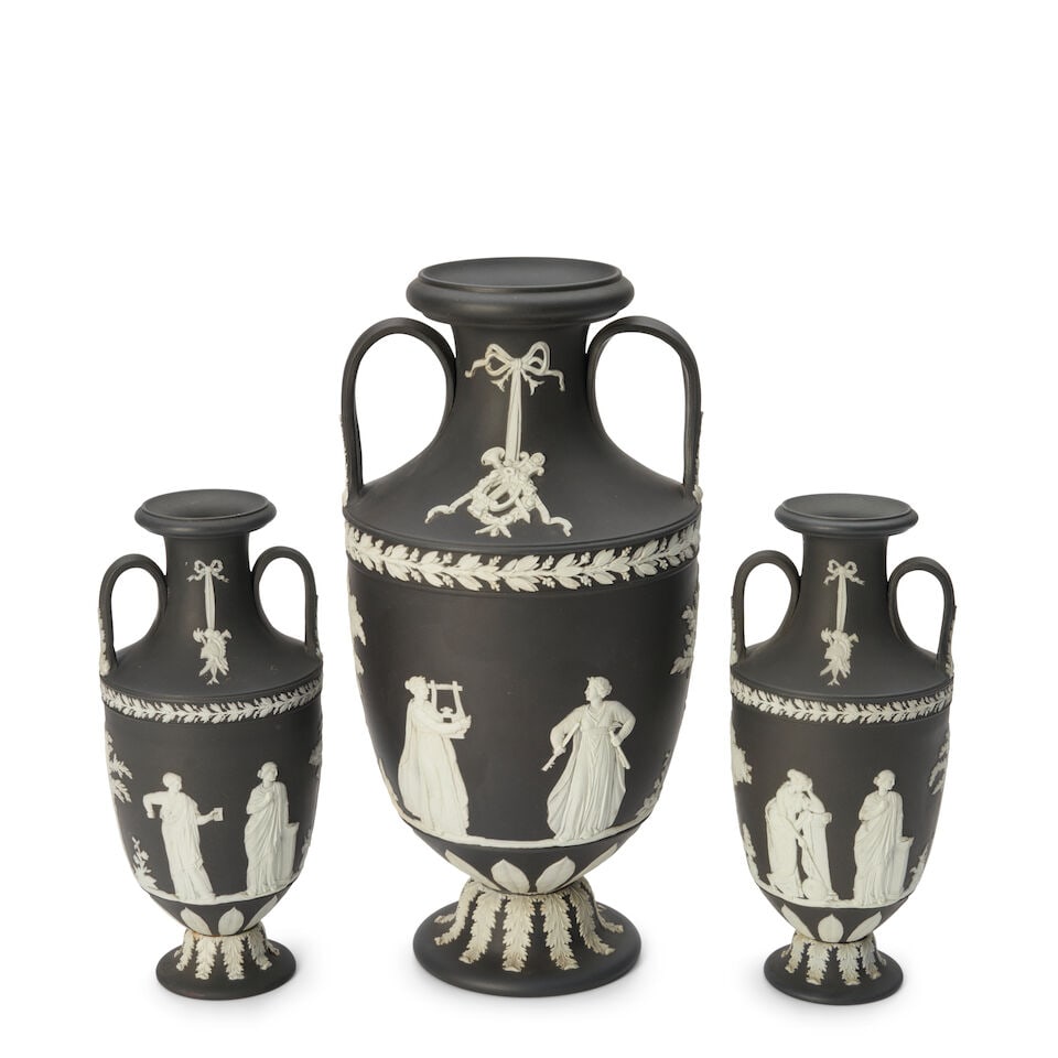 Three Wedgwood Black Jasper Dip Vases, England, late 19th/early 20th century,: Three Wedgwood Black Jasper Dip Vases, England, late 19th/early 20th century, each with applied white relief trophies to the necks above classical figures, impressed marks, ht. (2) 10, 14 1/2 in. For