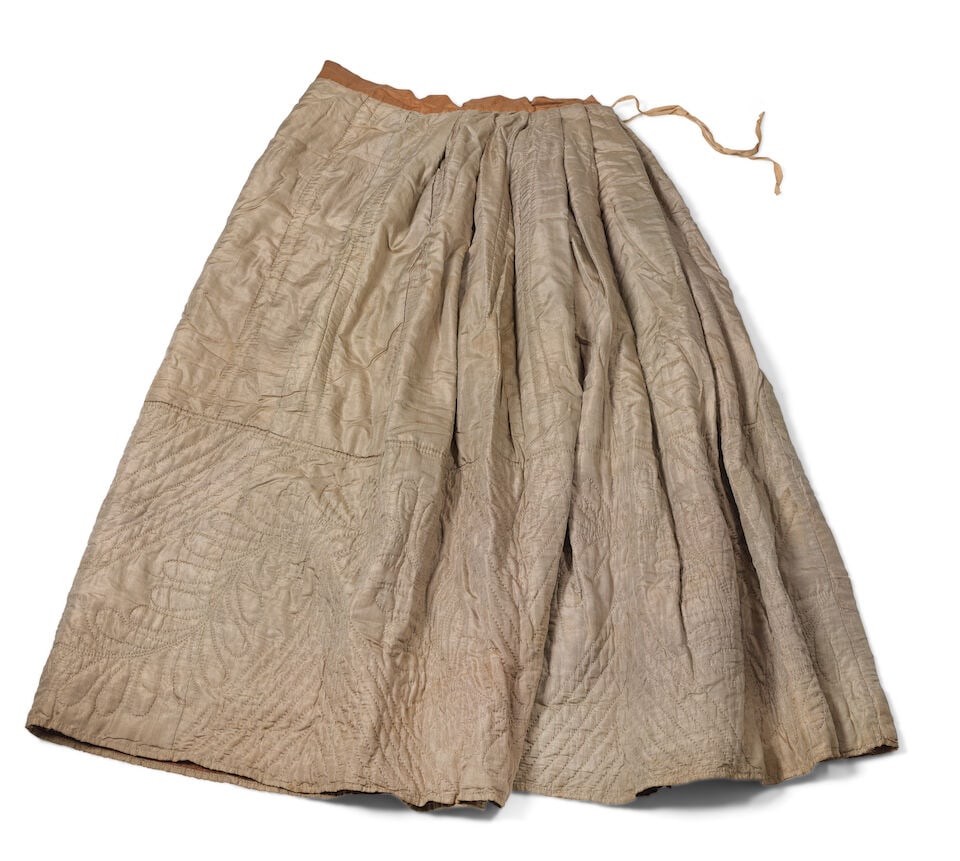 A quilted mushroom taffeta petticoat America, 1840s: A quilted mushroom taffeta petticoat America, 1840s Taupe silk petticoat quilted in feather & sawtooth motif, lined in burnt sienna glazed cotton 81cm wide, 97cm long For further information on this l