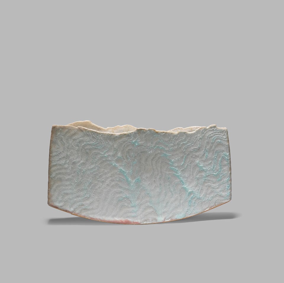 Peter Beard Flattened vessel: Peter Beard Flattened vessel Stoneware, mottled pale blue and white glazes with wave pattern decoration. 13.2 x 23.2 x 3.8 cm Underside with impressed artist's PFB monogram. This lot is subject to the